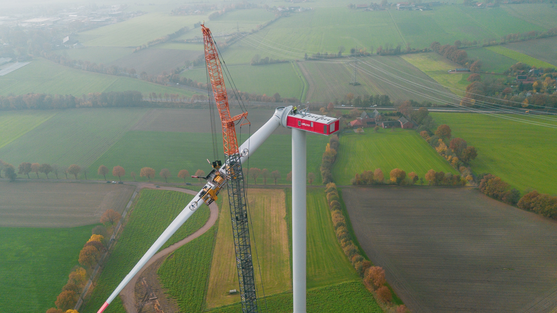 Windkraftanlage im Aufbau mit Kran. Drohnenansicht