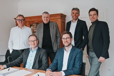  Gruppe von sechs Personen, die in einem Büro stehen