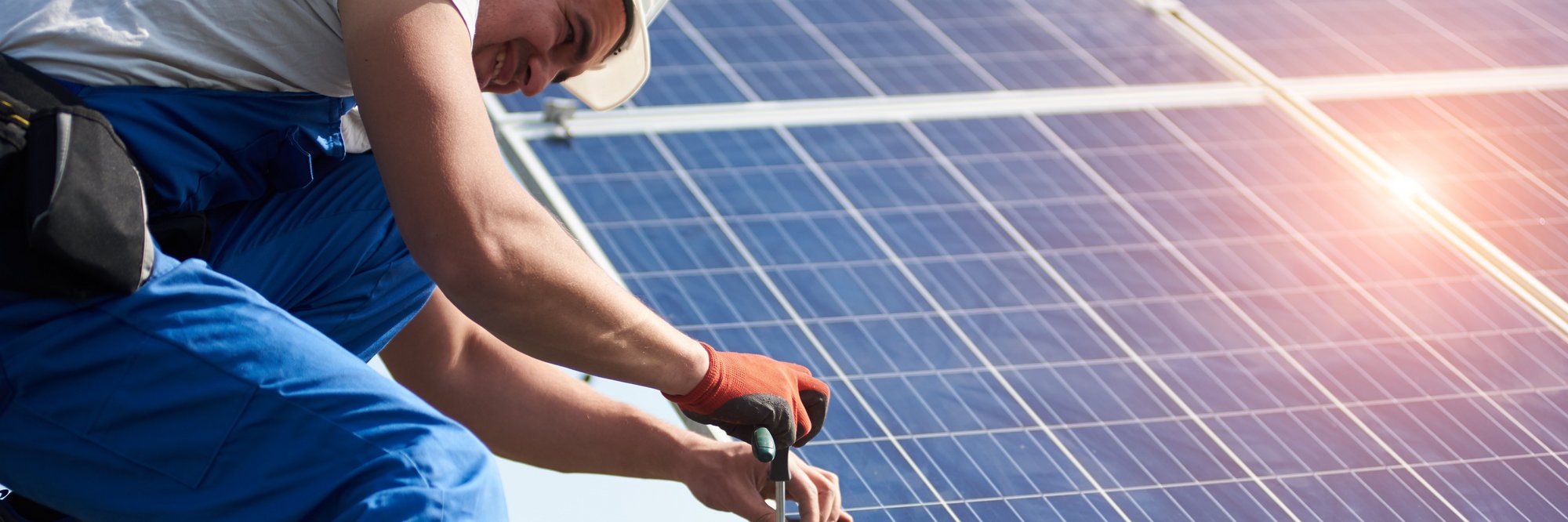 Person installiert Solarpanel auf dem Dach Das Bild zeigt eine Person, die auf einem Dach ein Solarpanel installiert.