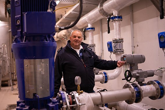 Pumpstation. Mann in Arbeitskleidung in einem Pumpstation.