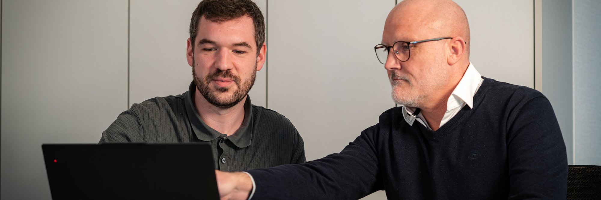 Zwei Personen schauen auf einen Laptop Zwei Personen schauen auf einen Laptop