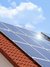 Das Bild zeigt ein Solarpanel auf einem Dach bei sonnigem Wetter.