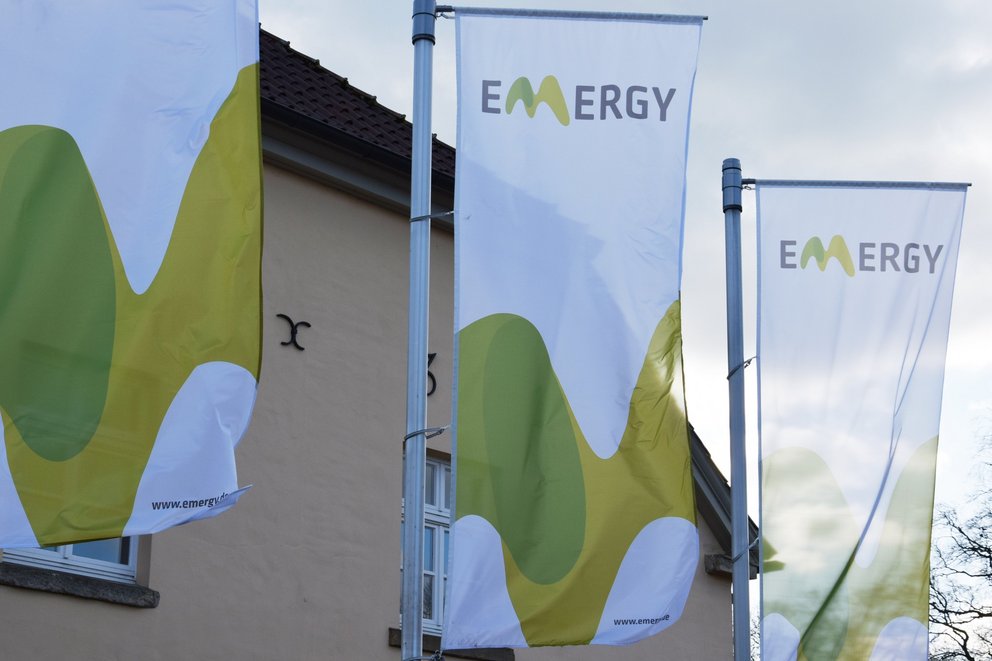 Fahnen. drei wehende Fahnen mit dem Logo von Emergy.