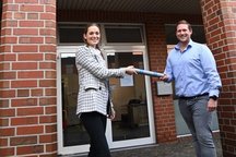 Eine symbolische Schlüsselübergabe findet statt.