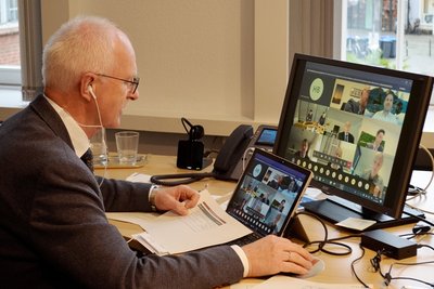 Bürgermeister Heinz Öhmann vonr Bildschirm mit Konferenzteilnehmern