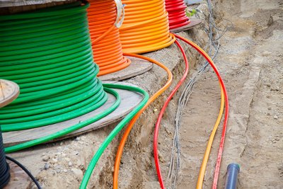 Drei Trommeln mit Glasfasern vor Graben