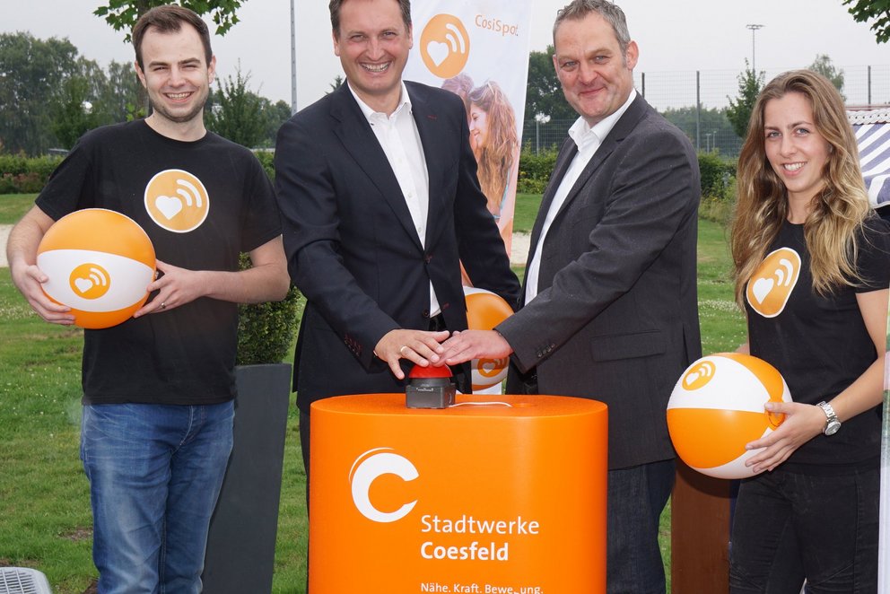 Vier Personen beim symbolischen Start. Vier Personen beim symbolischen Start eines Projekts der Stadtwerke Coesfeld – mit Knopfdruck und Markenbällen.