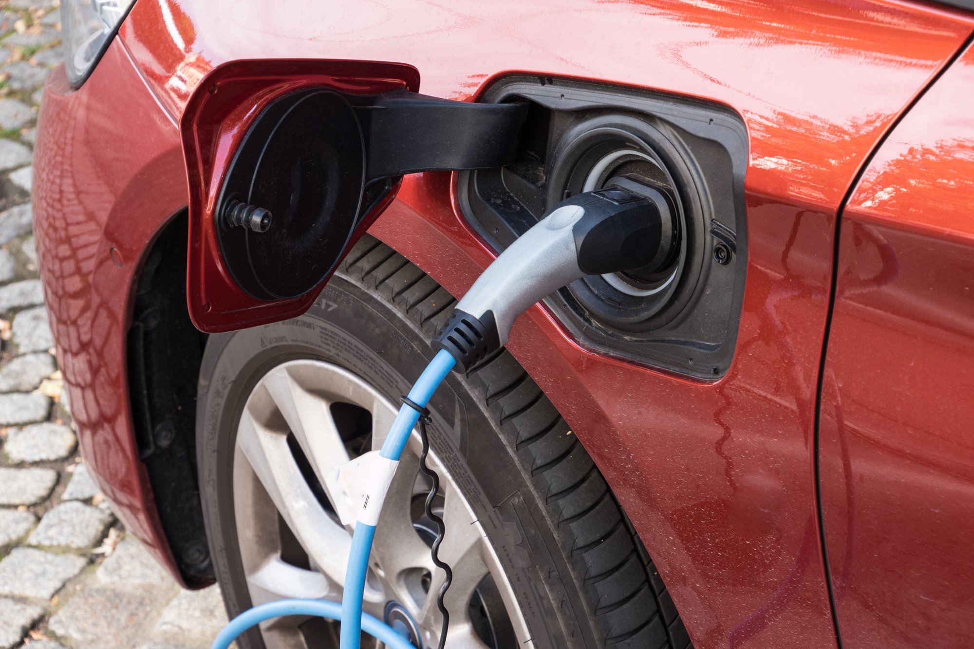 Elektroauto wird an Ladestation aufgeladen. Das Bild zeigt ein Elektroauto, das an einer Ladestation aufgeladen wird.