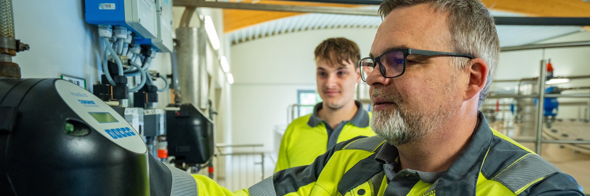 2 Mitarbeiter im Wasserwerk schauen auf die Messanlage