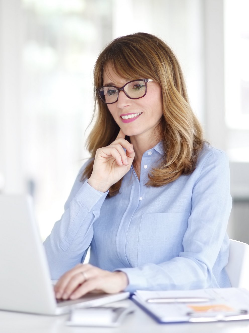 Person konzentriert sich auf Laptop am Schreibtisch Person sitzt an einem Schreibtisch, arbeitet mit einem Laptop und schaut nachdenklich auf den Bildschirm.